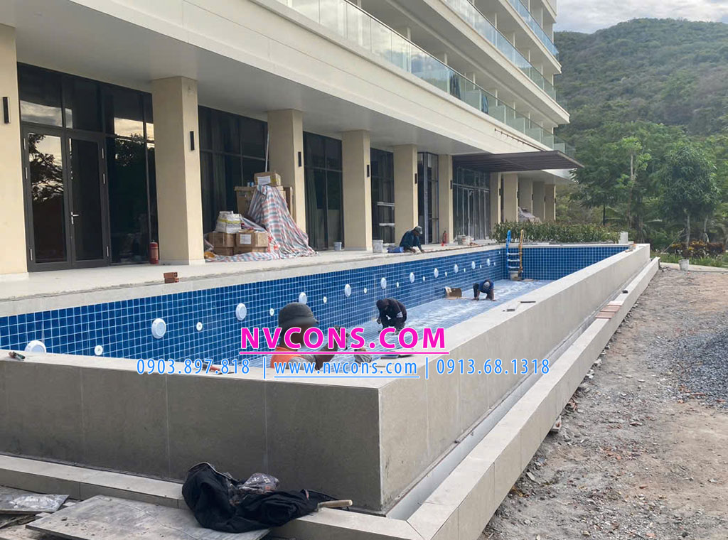 Các công nhân nhà thầu Nvcons đang thực hiện tỉ mĩ công đoạn dán gạch mosaic gốm sứ cao cấp hồ bơi